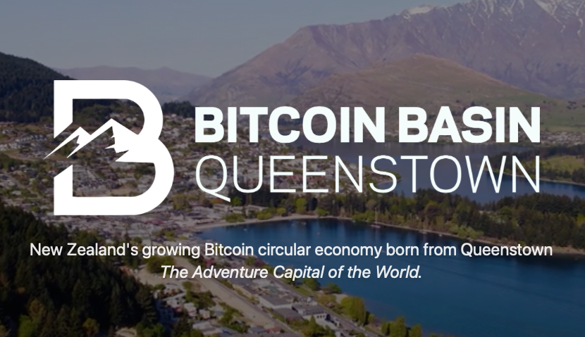Aerial view of Queenstown and the lake with Bitcoin Basin Queenstown logo and tagline in the foreground